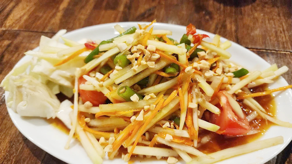 Fresh Thai papaya salad at The Baht with shredded green papaya, tomatoes, peanuts, and traditional seasonings