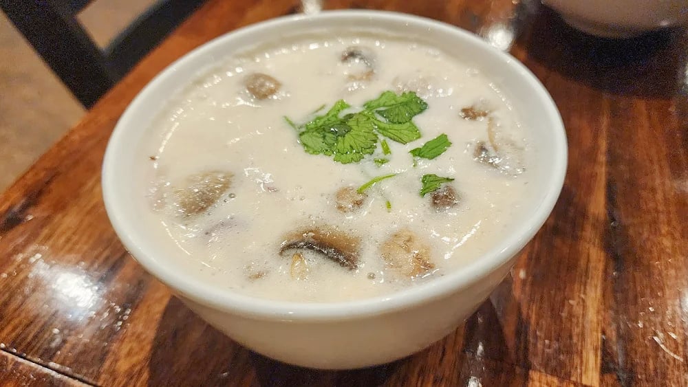 Creamy Tom Kah Chicken soup at The Baht with tender chicken, mushrooms, herbs, and rich coconut broth